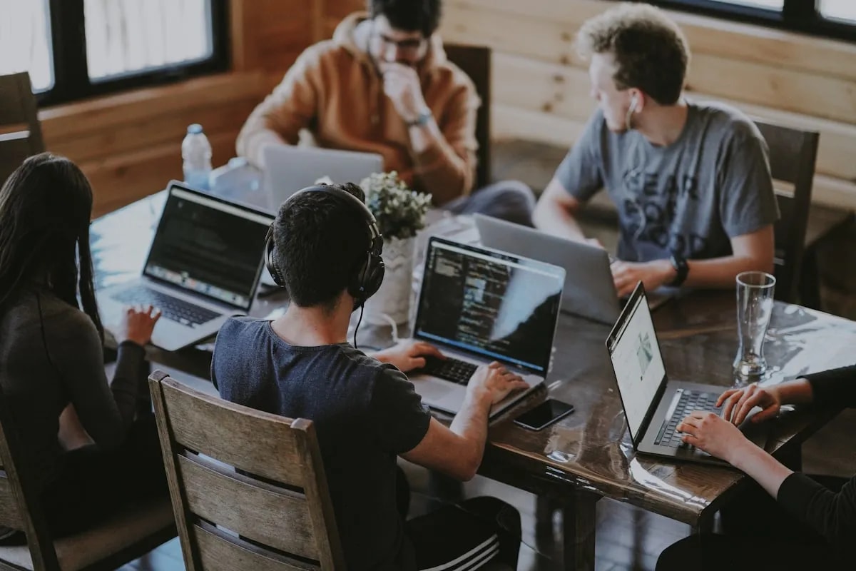 Team reviewing productivity reports together around a laptop