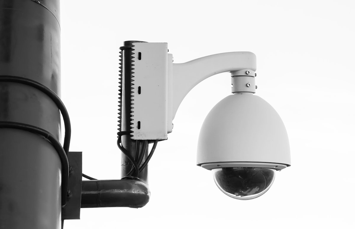 Security camera on a post, representing computer vision deployed for workplace attendance and safety